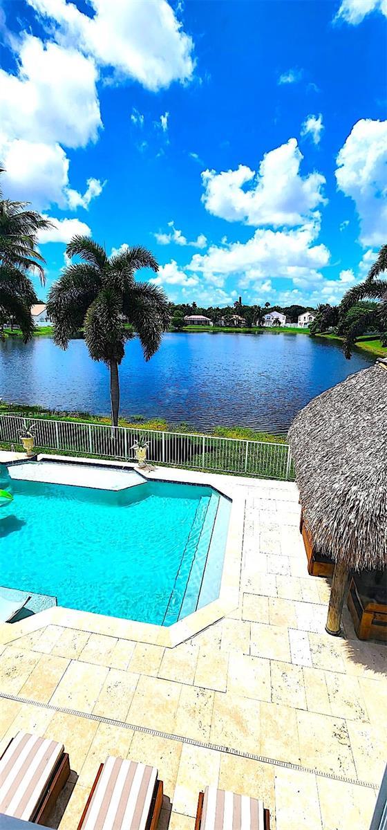 3460 SW 52nd St, Hollywood, FL 33312 - view of swimming pool featuring a water view, a fenced backyard, and a patio