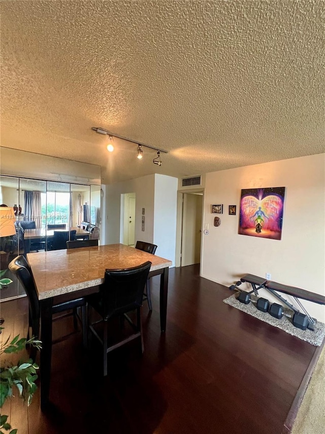 1470 NE 125th Ter Unit 814, North Miami, FL 33161 - dining area featuring a textured ceiling, rail lighting, and dark wood-type flooring