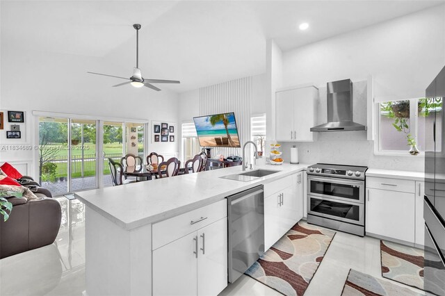 1211 E Wilshire Cir, Pembroke Pines, FL 33027 - kitchen featuring wall chimney exhaust hood, appliances with stainless steel finishes, a peninsula, open floor plan, and ceiling fan