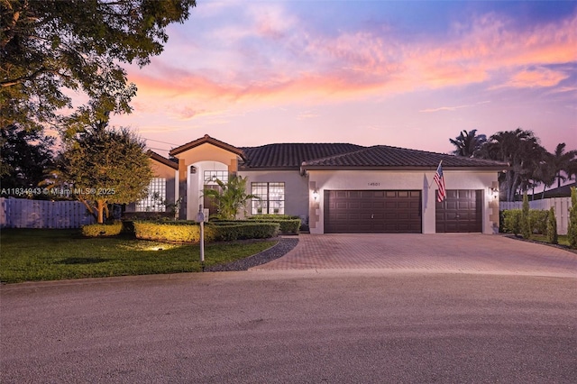 14501 SW 33rd Ct, Miramar, FL 33027 - mediterranean / spanish-style house with decorative driveway, a garage, stucco siding, and a tile roof