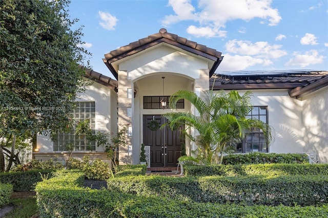 14501 SW 33rd Ct, Miramar, FL 33027 - entrance to property featuring stucco siding, a tiled roof, and roof mounted solar panels