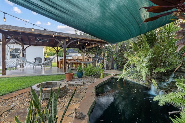 14501 SW 33rd Ct, Miramar, FL 33027 - fenced backyard featuring a gazebo, a fire pit, ceiling fan, a garden pond, and a patio area