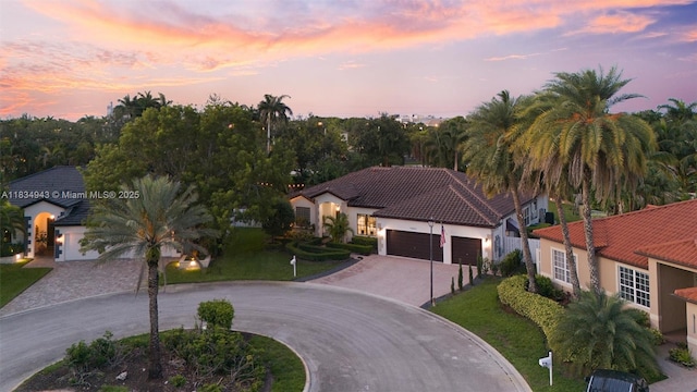 14501 SW 33rd Ct, Miramar, FL 33027 - mediterranean / spanish home featuring curved driveway, an attached garage, stucco siding, and a tile roof