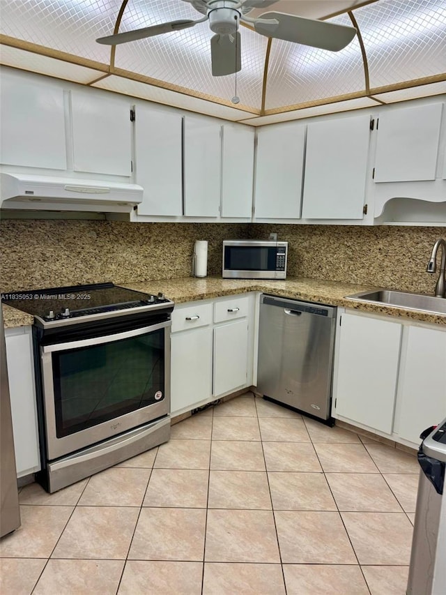201 180th Dr Unit 114, Sunny Isles Beach, FL 33160 - kitchen featuring stainless steel appliances, under cabinet range hood, decorative backsplash, and white cabinets