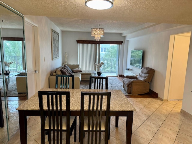 201 180th Dr Unit 114, Sunny Isles Beach, FL 33160 - dining space with a chandelier, a textured ceiling, and light tile patterned flooring