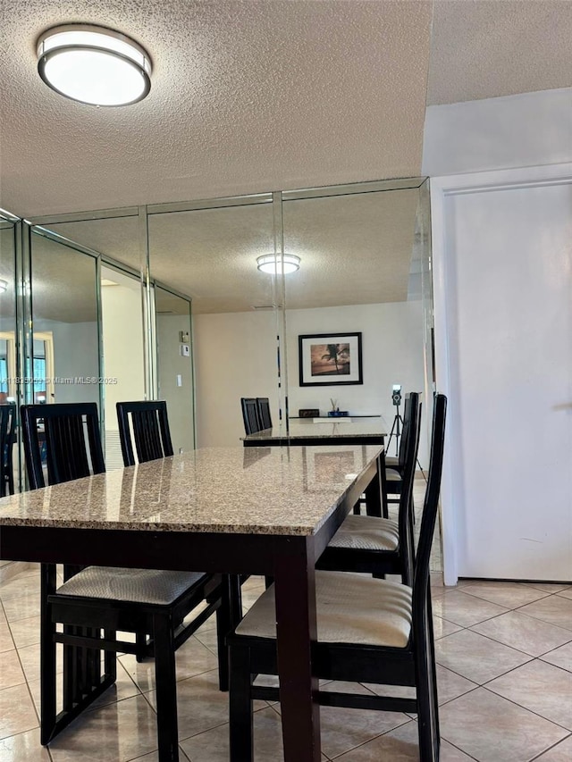201 180th Dr Unit 114, Sunny Isles Beach, FL 33160 - dining space with a textured ceiling and light tile patterned floors