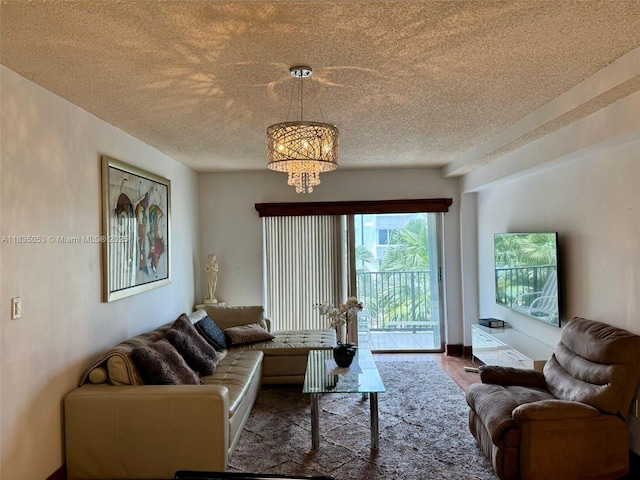 201 180th Dr Unit 114, Sunny Isles Beach, FL 33160 - living room featuring a textured ceiling, a chandelier, and wood finished floors