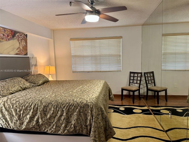 201 180th Dr Unit 114, Sunny Isles Beach, FL 33160 - bedroom with a textured ceiling, wood finished floors, and ceiling fan