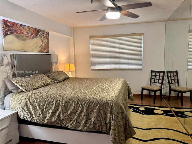 201 180th Dr Unit 114, Sunny Isles Beach, FL 33160 - bedroom with a textured ceiling, wood finished floors, and a ceiling fan
