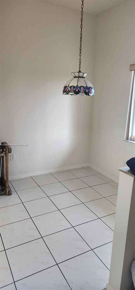 9575 Weldon Cir Unit C406, Tamarac, FL 33321 - unfurnished dining area with light tile patterned floors and baseboards