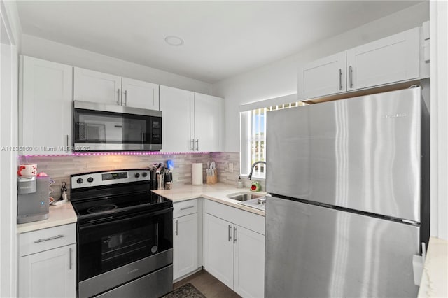 2418 NW 52nd St, Tamarac, FL 33309 - kitchen featuring stainless steel appliances, white cabinets, and tasteful backsplash