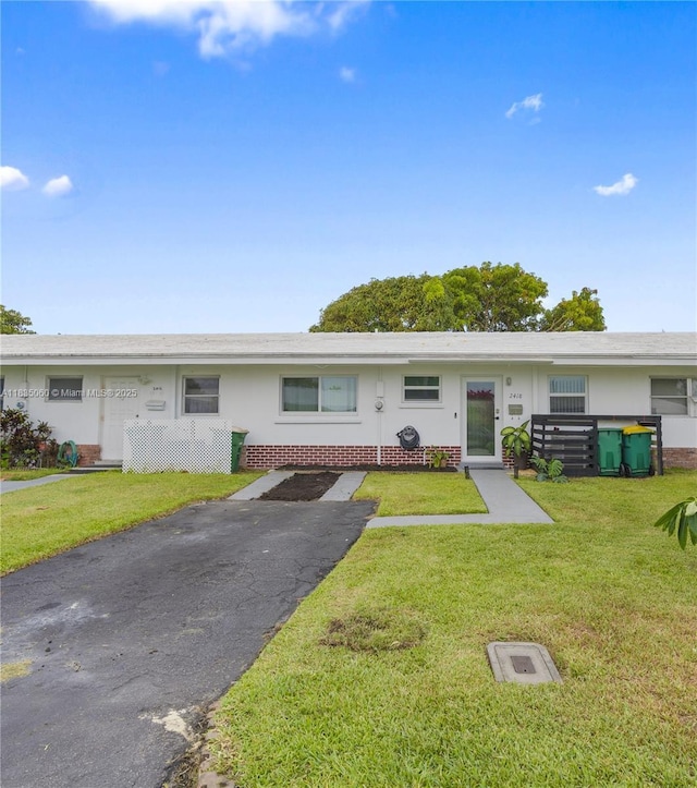2418 NW 52nd St, Tamarac, FL 33309 - view of front of property with brick siding, a front lawn, asphalt driveway, and stucco siding