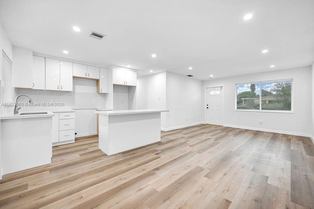 5201 Wiley St, Hollywood, FL 33021 - kitchen featuring a kitchen island, recessed lighting, light wood-style floors, white cabinetry, and light countertops