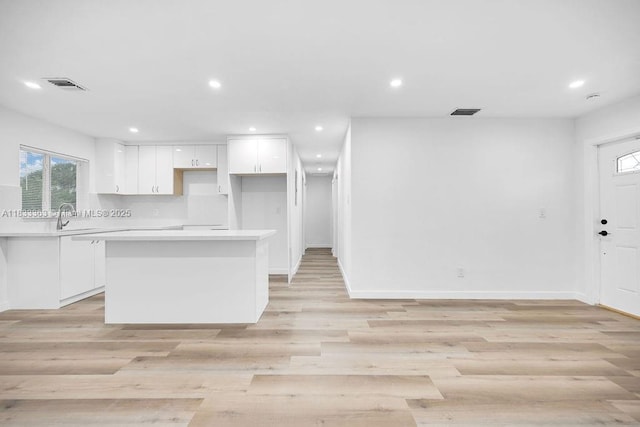 5201 Wiley St, Hollywood, FL 33021 - kitchen featuring white cabinetry, a kitchen island, light countertops, recessed lighting, and light wood finished floors