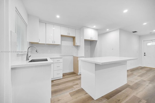 5201 Wiley St, Hollywood, FL 33021 - kitchen with white cabinetry, recessed lighting, light wood-style flooring, a kitchen island, and backsplash