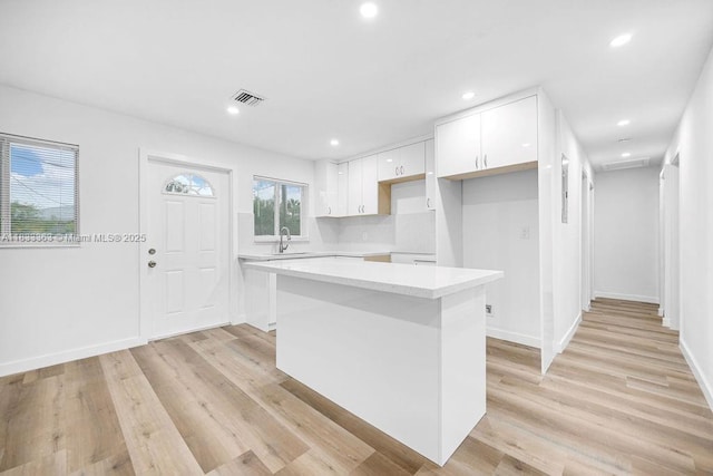 5201 Wiley St, Hollywood, FL 33021 - kitchen with white cabinetry, a kitchen island, light wood-style flooring, recessed lighting, and light countertops
