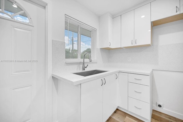 5201 Wiley St, Hollywood, FL 33021 - kitchen with light countertops, white cabinetry, light wood-type flooring, and decorative backsplash
