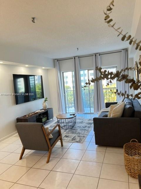 250 181st Dr Unit 212, Sunny Isles Beach, FL 33160 - living area with light tile patterned floors and a textured ceiling