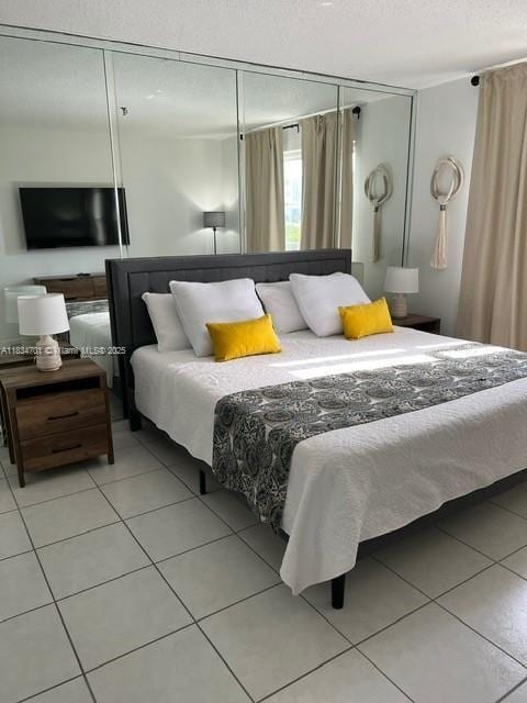 250 181st Dr Unit 212, Sunny Isles Beach, FL 33160 - tiled bedroom featuring a closet and a textured ceiling