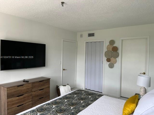 250 181st Dr Unit 212, Sunny Isles Beach, FL 33160 - bedroom with a textured ceiling and a closet