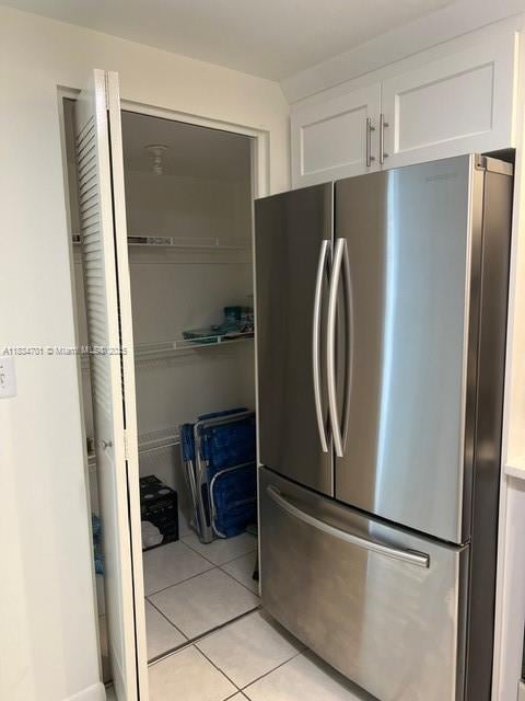 250 181st Dr Unit 212, Sunny Isles Beach, FL 33160 - kitchen with freestanding refrigerator, white cabinetry, and light tile patterned floors