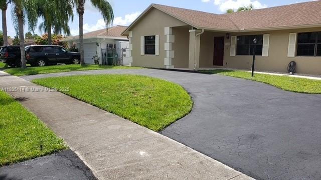 12600 SW 10th Ct, Davie, FL 33325 - ranch-style home with stucco siding, curved driveway, and a front yard