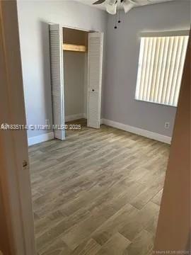12600 SW 10th Ct, Davie, FL 33325 - unfurnished bedroom with a closet, wood finished floors, and a ceiling fan