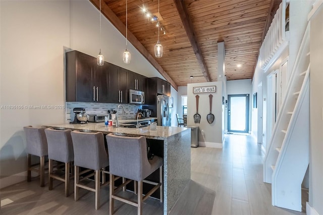 10391 Jasmine Ct, Pembroke Pines, FL 33026 - kitchen with a wooden ceiling with exposed beams, stainless steel appliances, a breakfast bar, a peninsula, and tasteful backsplash