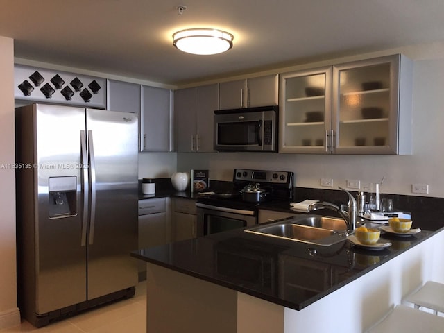 1871 NW S River Dr Unit 1904, Miami, FL 33125 - kitchen with stainless steel appliances, dark countertops, gray cabinets, glass insert cabinets, and a peninsula