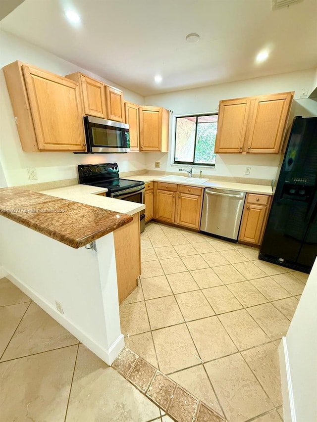 5012 SW 40th Ave Unit 5012, Fort Lauderdale, FL 33312 - kitchen with stainless steel appliances, a peninsula, light tile patterned floors, light brown cabinets, and recessed lighting