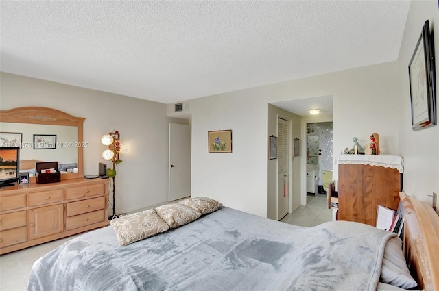 4350 Hillcrest Dr Unit 306, Hollywood, FL 33021 - bedroom with light tile patterned flooring, a textured ceiling, and connected bathroom