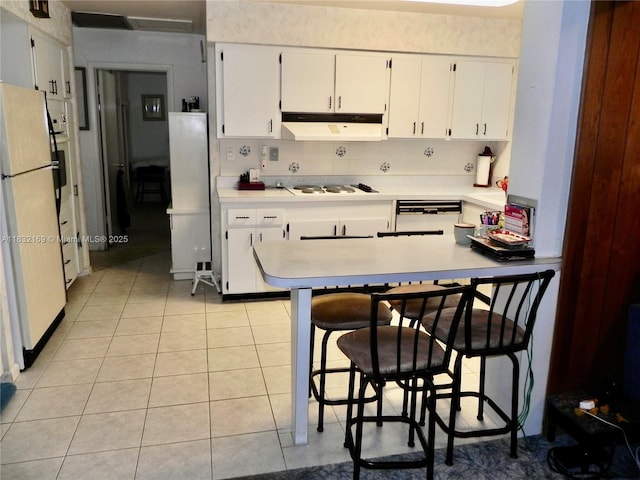 8225 SW 97th St, Miami, FL 33156 - kitchen featuring a peninsula, white appliances, under cabinet range hood, light countertops, and light tile patterned floors