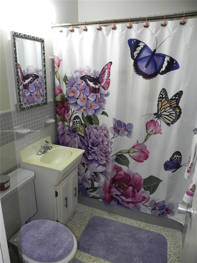 8225 SW 97th St, Miami, FL 33156 - full bathroom with speckle patterned floor, tile walls, vanity, a shower with curtain, and a wainscoted wall
