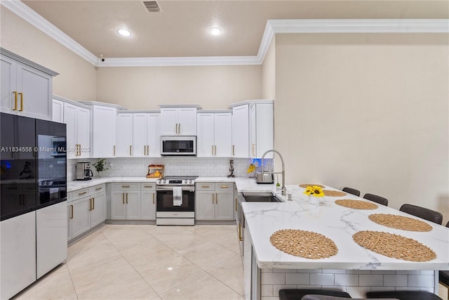 8346 SW 51st St, Davie, FL 33328 - kitchen with stainless steel electric stove, a peninsula, a kitchen bar, crown molding, and decorative backsplash