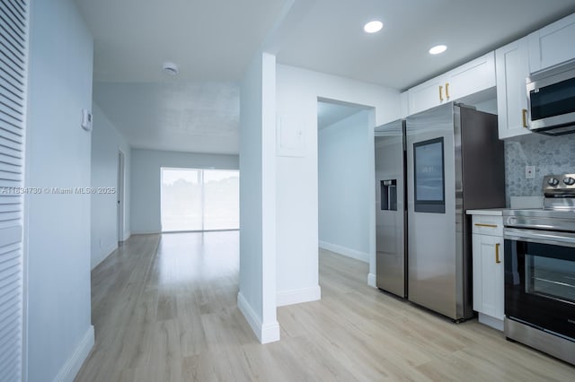 9601 Sunrise Lakes Blvd Unit 311, Sunrise, FL 33322 - kitchen with appliances with stainless steel finishes, white cabinetry, light wood-style flooring, decorative backsplash, and recessed lighting