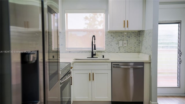 9601 Sunrise Lakes Blvd Unit 311, Sunrise, FL 33322 - kitchen featuring appliances with stainless steel finishes, white cabinetry, decorative backsplash, light stone countertops, and healthy amount of natural light