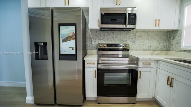 9601 Sunrise Lakes Blvd Unit 311, Sunrise, FL 33322 - kitchen featuring appliances with stainless steel finishes, white cabinets, tasteful backsplash, and light wood-type flooring