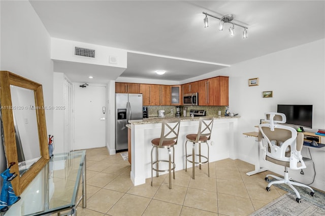 401 Ocean Dr Unit 1024, Miami Beach, FL 33139 - kitchen featuring appliances with stainless steel finishes, a peninsula, glass insert cabinets, and light tile patterned flooring