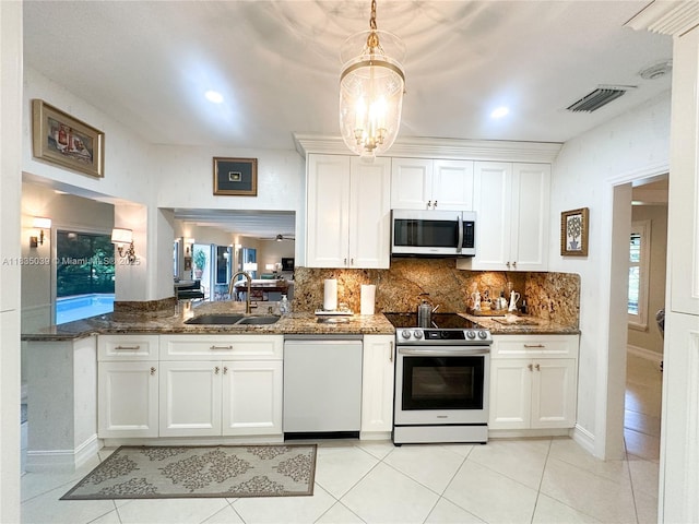 8225 SW 151st St, Palmetto Bay, FL 33158 - kitchen featuring appliances with stainless steel finishes, white cabinets, decorative backsplash, dark stone counters, and recessed lighting