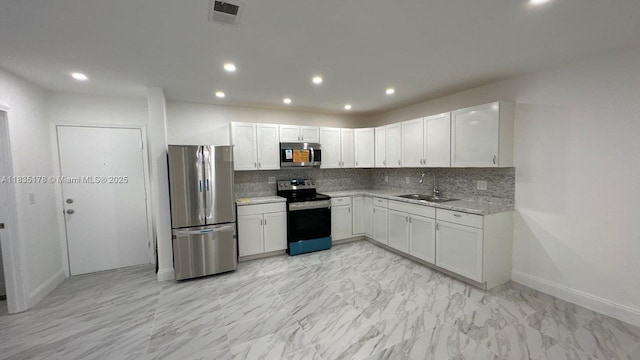 2251 NW 48th Ter Unit 214, Lauderhill, FL 33313 - kitchen featuring appliances with stainless steel finishes, decorative backsplash, white cabinetry, recessed lighting, and light marble finish flooring