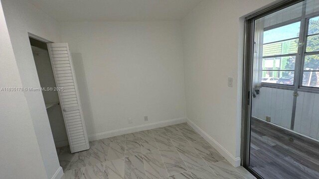 2251 NW 48th Ter Unit 214, Lauderhill, FL 33313 - unfurnished bedroom with marble look tile flooring and baseboards