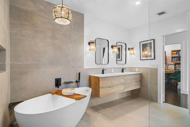 1231 96th St, Bay Harbor Islands, FL 33154 - full bath featuring tile walls, a freestanding bath, double vanity, and tile patterned floors