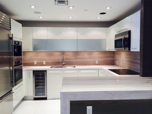 17121 Collins Ave Unit 2803, Sunny Isles Beach, FL 33160 - kitchen with stainless steel appliances, modern cabinets, wine cooler, white cabinets, and light countertops
