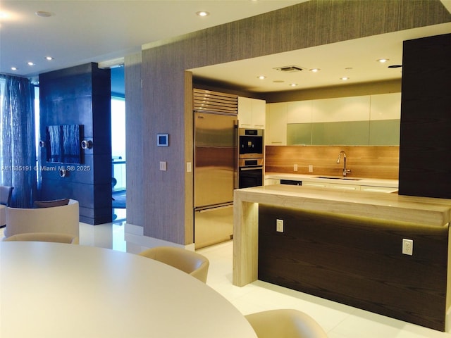 17121 Collins Ave Unit 2803, Sunny Isles Beach, FL 33160 - kitchen with built in refrigerator, white cabinets, modern cabinets, light countertops, and recessed lighting