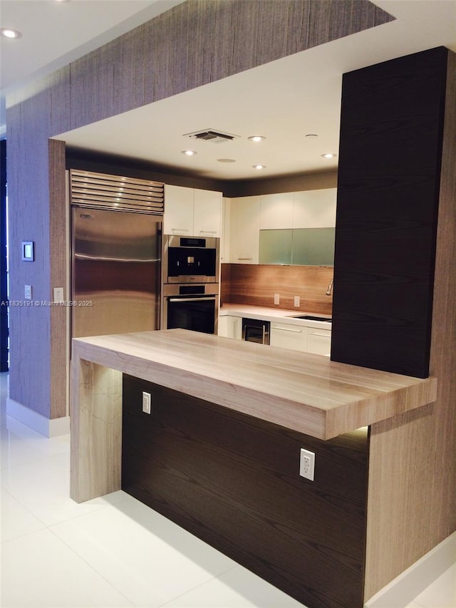 17121 Collins Ave Unit 2803, Sunny Isles Beach, FL 33160 - kitchen with modern cabinets, white cabinetry, wine cooler, recessed lighting, and stainless steel appliances
