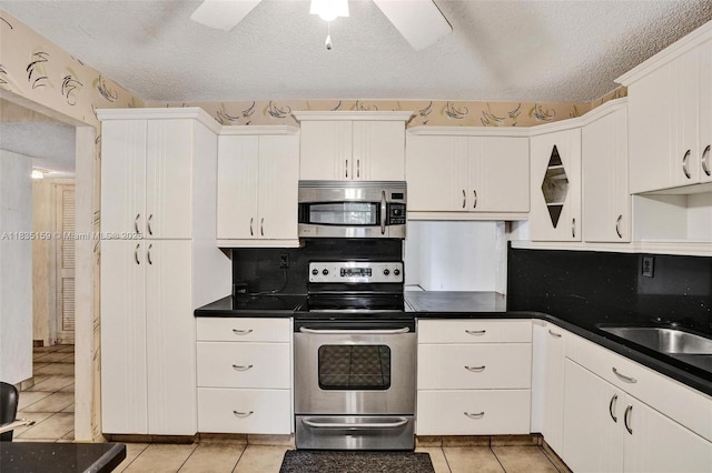 4965 E Sabal Palm Blvd Unit 207, Tamarac, FL 33319 - kitchen featuring stainless steel appliances, a textured ceiling, white cabinets, light tile patterned floors, and ceiling fan