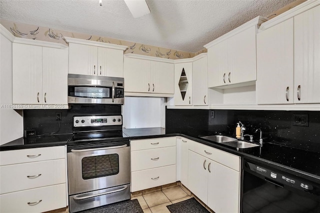 4965 E Sabal Palm Blvd Unit 207, Tamarac, FL 33319 - kitchen featuring appliances with stainless steel finishes, a textured ceiling, light tile patterned flooring, white cabinetry, and dark countertops