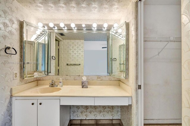 4965 E Sabal Palm Blvd Unit 207, Tamarac, FL 33319 - bathroom with wallpapered walls, vanity, and a walk in closet