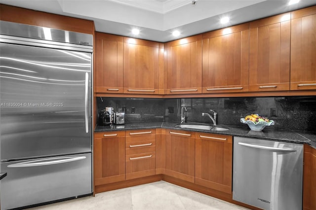 333 Las Olas Way Unit 405, Fort Lauderdale, FL 33301 - kitchen with appliances with stainless steel finishes, backsplash, brown cabinets, crown molding, and dark stone counters