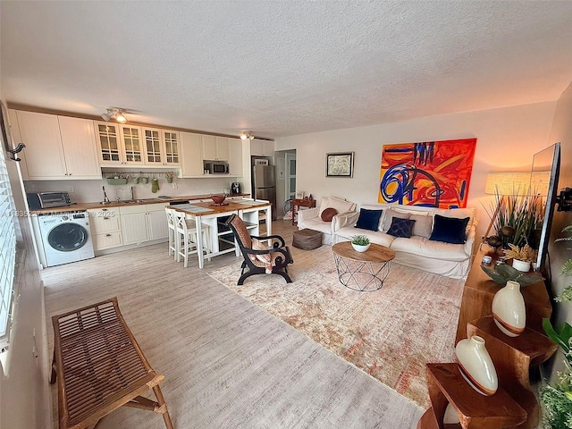 224 Meridian Ave Unit 10, Miami Beach, FL 33139 - living area with washer / dryer, light wood-type flooring, and a textured ceiling